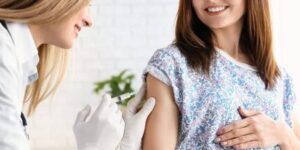 mujer embarazada vacunandose contra la gripe